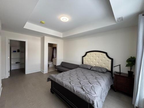 a bedroom with a bed and a couch in it at Cozy Suite in Brand New Luxury Home in Toronto