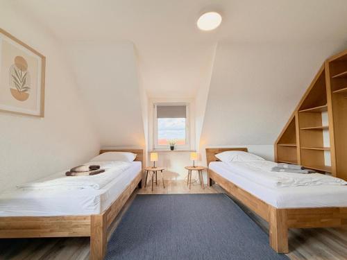 a room with two beds and a window at Pension Bockenem Extra in Bockenem