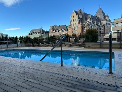 a swimming pool in front of a large building at WaterFalls Hotel - Suite in Falls Downtown with pool in Victoria