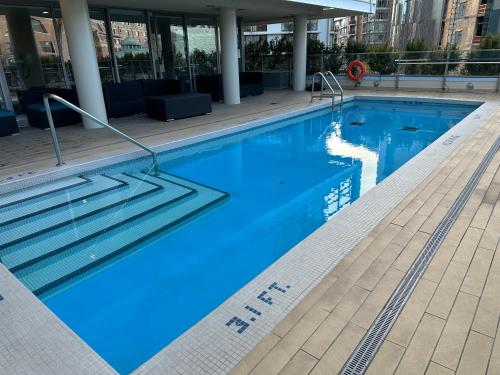 a large swimming pool with blue water in a building at WaterFalls Hotel - Suite in Falls Downtown with pool in Victoria