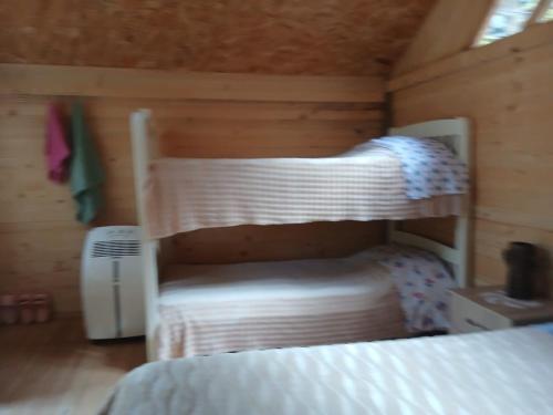 a bedroom with two bunk beds in a cabin at Bujtina Liqeni i Shkopetit in Madhesh