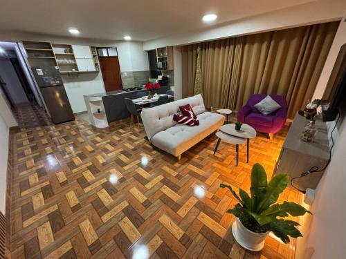a living room with a couch and a table and a kitchen at Solena Apartamentos Tacna in Tacna