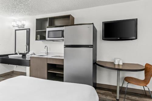 a kitchen with a refrigerator and a table with a chair at Studio 6 King of Prussia PA Philadelphia in King of Prussia