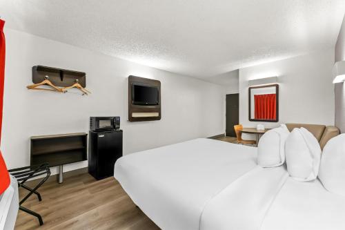 Una habitación de hotel con una cama grande y un televisor. en Studio 6 King of Prussia PA Philadelphia, en King of Prussia