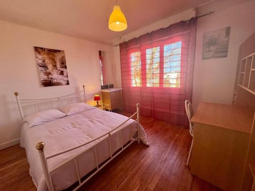 a bedroom with a bed and a desk and a window at Villa Amistad- Chambre Olivier - centre - parking - jardin - logement partagé in Mont-de-Marsan