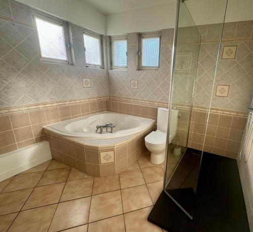 une salle de bain avec baignoire et toilettes dans l'établissement Villa Amistad- Chambre Olivier - centre - parking - jardin - logement partagé, à Mont-de-Marsan