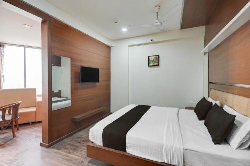 a bedroom with a bed and a desk and a television at Collection O Motipura Bus Terminal Formerly Hotel Navjivan in Himatnagar