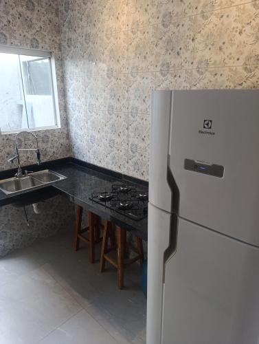 a kitchen with a white refrigerator and a sink at Espaço jr in Andradina