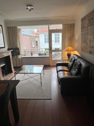 a living room with a leather couch and a glass table at Franciscus in Bergen op Zoom