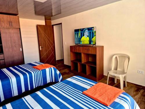 a hotel room with two beds and a tv at Modern, comfortable and convenient space in Sucre