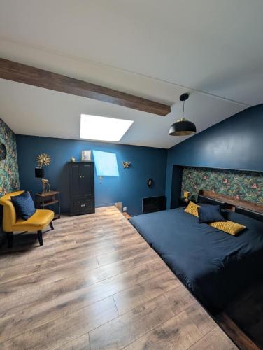 - une chambre avec un grand lit et une chaise jaune dans l'établissement Gite de campagne avec SPA privatif, à Saint-Sauvant