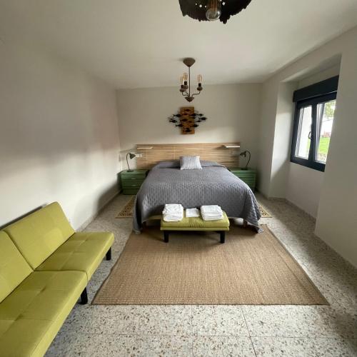 ein Schlafzimmer mit einem Bett, einer Couch und einem Kronleuchter in der Unterkunft Jardín Pozobal in Hontoria