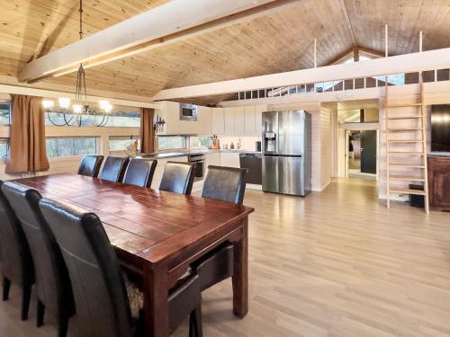 a dining room with a wooden table and chairs at Utsikt mot fjellene Ski in out 16 sengeplasser in Aurdal