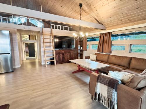 a living room with a couch and a table at Utsikt mot fjellene Ski in out 16 sengeplasser in Aurdal