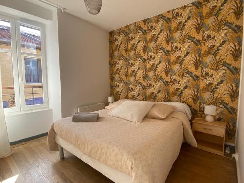 a bedroom with a bed with a floral wallpaper at Appartement T3 en duplex Veynes in Veynes