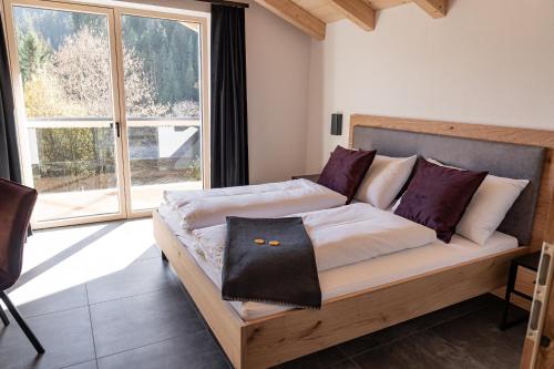 a bed in a room with a large window at Rupertichalet in Zell am See