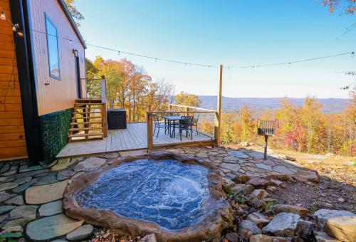 a hot tub on a patio next to a house at Blooming Redbud Treehouse with private hot tub in Wildwood