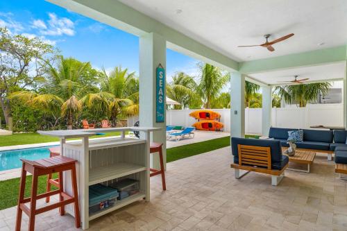 een woonkamer met een zwembad en een patio bij Emerald Oasis Deluxe Waterfront Gem, Heated Pool with Dock in Marathon