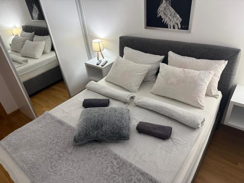 een slaapkamer met een bed met witte kussens bij Apartman Teodora in Donje Mladice