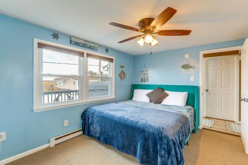 ein blaues Schlafzimmer mit einem Bett und einem Deckenventilator in der Unterkunft Walk to Public Beach Bayfront Jersey Home with View in Fortescue