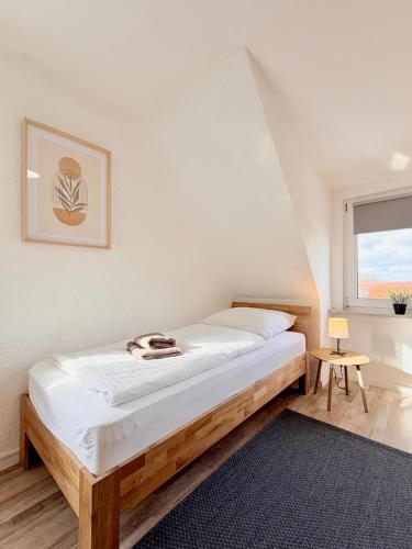 a bedroom with a bed and a window at Hotel & Pension Bockenem in Bockenem