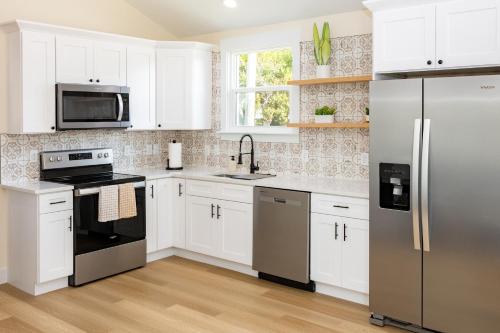 a kitchen with white cabinets and a stainless steel refrigerator at Free parking, Free WiFi 2 bed home in Tampa