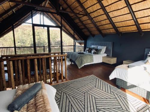 a room with two beds and a balcony with windows at Edge of the Crater in Venterskroon