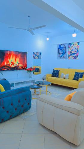 a living room with two couches and a fireplace at Staycation One and Two Bedroom apartment Mombasa in Mombasa