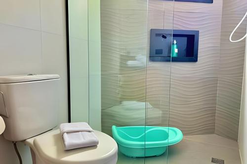 a bathroom with a toilet and a glass shower at Villa Cristalle - Campos do Jordão in Campos do Jordão