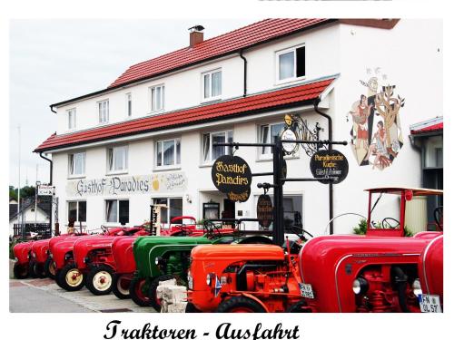 a row of red and green trucks parked in front of a building at Adam & Eva Gasthof Paradies mit Hotel in Vogt