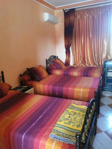 two beds sitting in a room with curtains at Motel in Oulad Barrehil