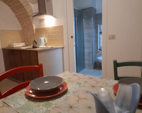 アルベロベッロにあるNonna Livia - vicino centro storico Trulliのキッチン(テーブル、皿付)