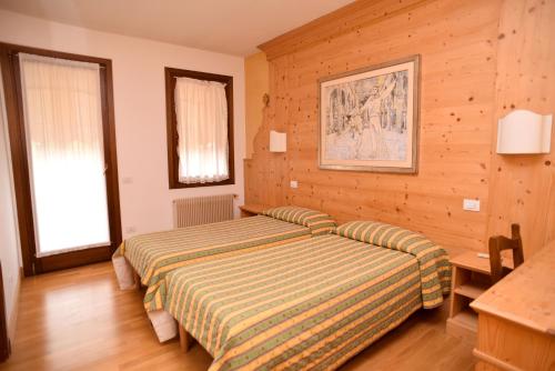 1 dormitorio con 1 cama en una habitación con paredes de madera en Albergo Da Gildo, en Follina