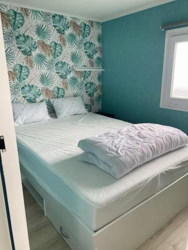 a bed in a room with a blue wall at Chalet D'Mar in Wenduine