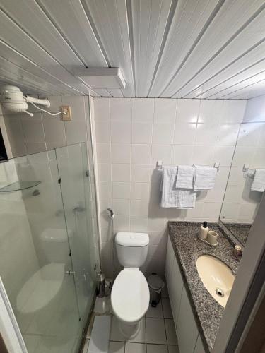 a bathroom with a toilet and a shower and a sink at Flat Completo Natal Praia do Meio in Natal