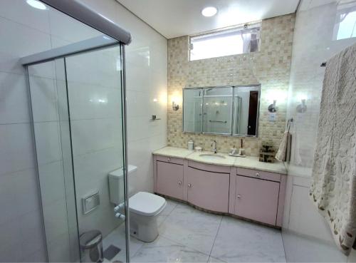 a bathroom with a toilet and a sink and a shower at Pousada casa dos sonhos in São Gabriel