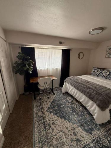 a bedroom with a bed and a table and a window at Cozy and well located 2-bedroom basement in Provo