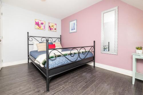 a bedroom with a black bed and a pink wall at Stylish Ottawa Getaway for 5 in Ottawa