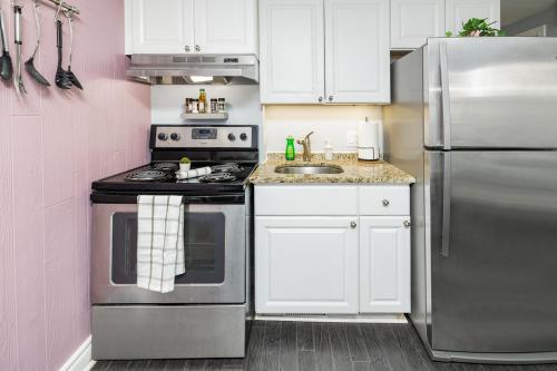 a kitchen with white cabinets and a stainless steel refrigerator at Stylish Ottawa Getaway for 5 in Ottawa