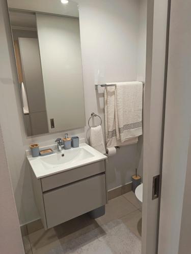 a bathroom with a sink and a mirror and a toilet at Ellipse Lux Hotel - Apartment in Midrand