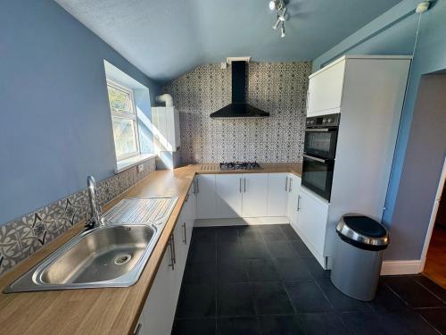 a kitchen with white cabinets and a sink at The Ferns in Mitcheldean
