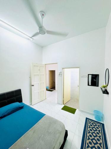 a white bedroom with a bed and a tv at AL Homestay Pendang in Pendang