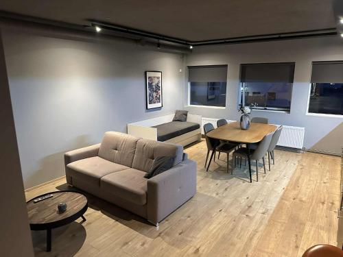 a living room with a couch and a table at Modern Apartment With Hot Tub in Akureyri in Akureyri