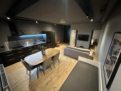 a kitchen and living room with a wooden table and chairs at Modern Apartment With Hot Tub in Akureyri in Akureyri