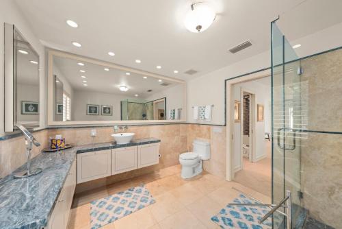 Un baño con inodoro, lavabo y ducha. en Slice of Paradise, en James Cipriani Heliport