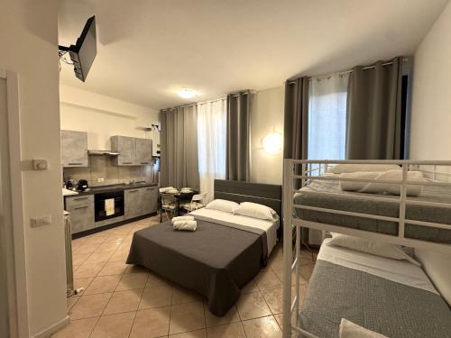 a bedroom with two bunk beds and a kitchen at Aparthotel Dergano 2 near metro stop in Milan