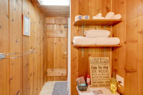 ein Badezimmer mit Holzwänden und einer Dusche mit Handtüchern in der Unterkunft Cozy Rivershire Retreat Cabin Near Traverse City in Devils Elbow