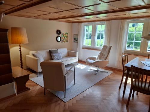 ein Wohnzimmer mit Sofa und Tisch in der Unterkunft Mattishüüsli - Chalet with a little garden in Luchsingen