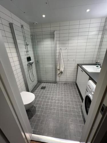 a bathroom with a shower and a toilet and a sink at Modern downtown apartment in Fredrikstad