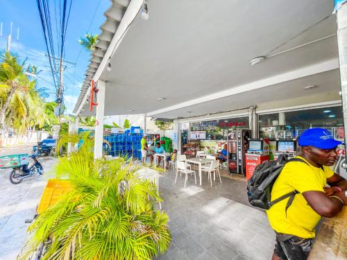Un hombre con un sombrero azul parado afuera de una tienda en CARIBBEAN TROPICAL STUDIOS and SUITES - BEACH CLUB, SPA, RESTAURANTS - playa LOS CORALES - DUCASSI, en Punta Cana